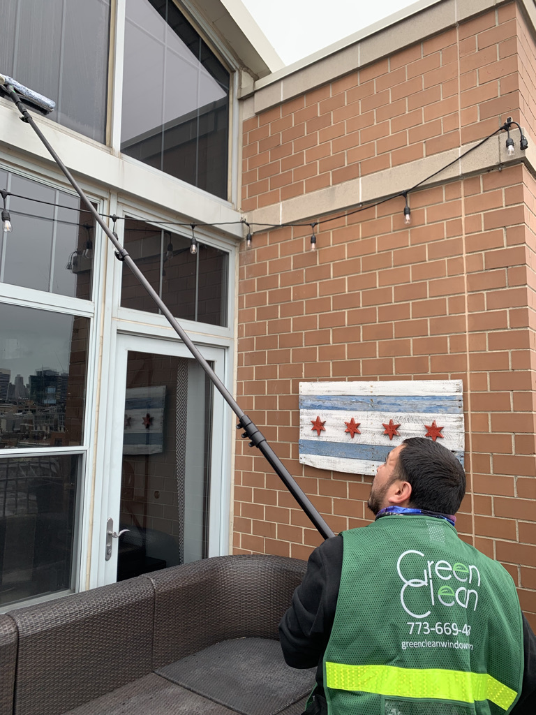 Commercial window washer using a T bar to clean exterior windows in Chicago