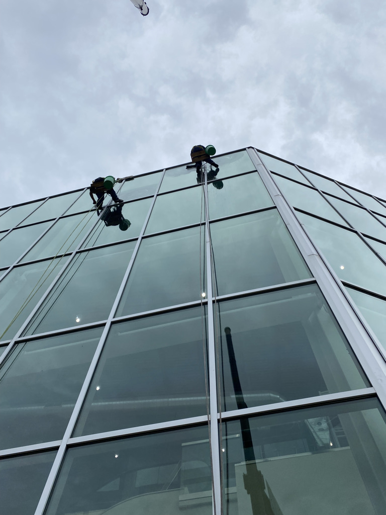 Two window washers using rope & harness to clean Chicago office mid-rise.