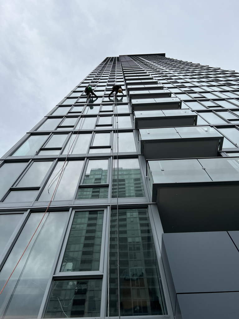 Commercial window cleaners washing high rise exterior windows