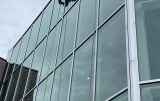 Window cleaning at the top of a mid rise retail building