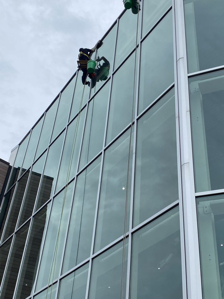Window cleaning at the top of a mid rise retail building