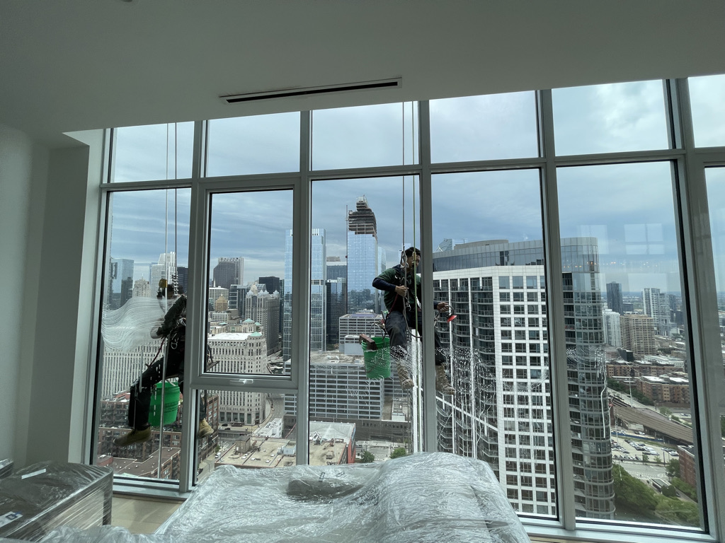 Green Clean Window workers cleaning high rise window