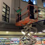 Crew uses lift to clean windows inside a grocery store