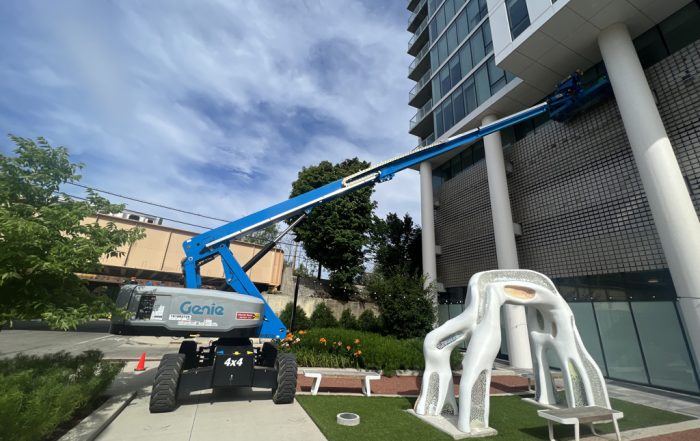 Green Clean using Genie articulated boom lift to clean a luxury apartment building