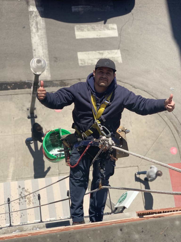 high rise window washer worker using proper safety equipment